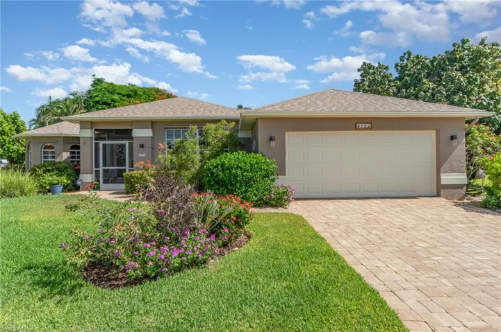 Single story home with stucco siding, a sunroom, an attached garage, decorative driveway, and a shingled roof