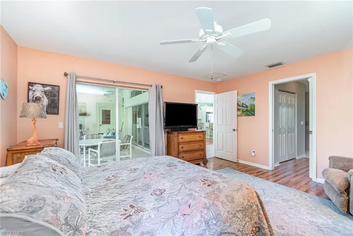 Bedroom featuring wood finished floors, access to exterior, and ceiling fan