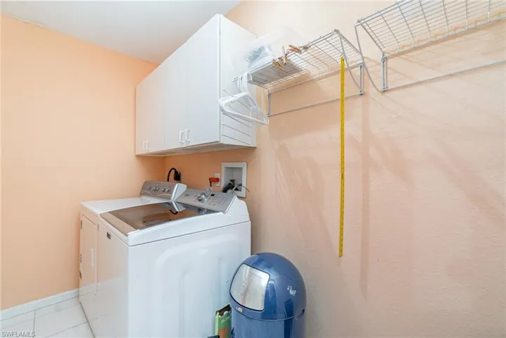 Washroom with cabinet space, separate washer and dryer, and tile patterned flooring