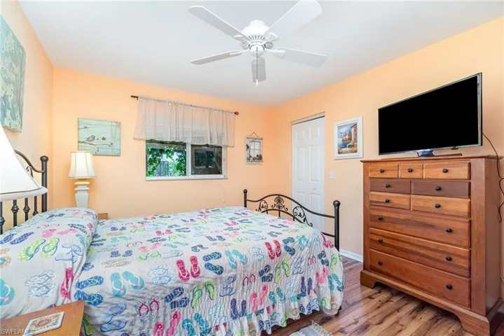 Bedroom featuring wood finished floors, a closet, and a ceiling fan