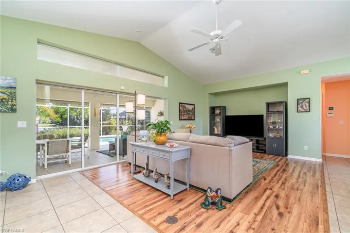 Living area featuring ceiling fan, light wood-style floors, and high vaulted ceiling