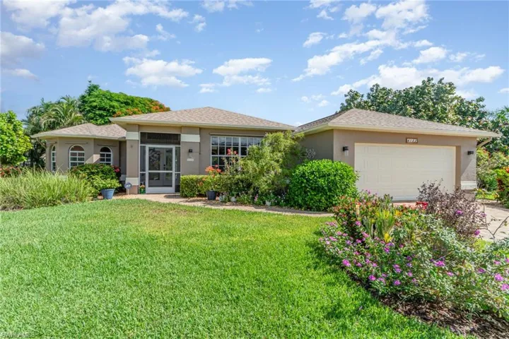View of front facade with an attached garage, stucco siding, a front yard, and driveway