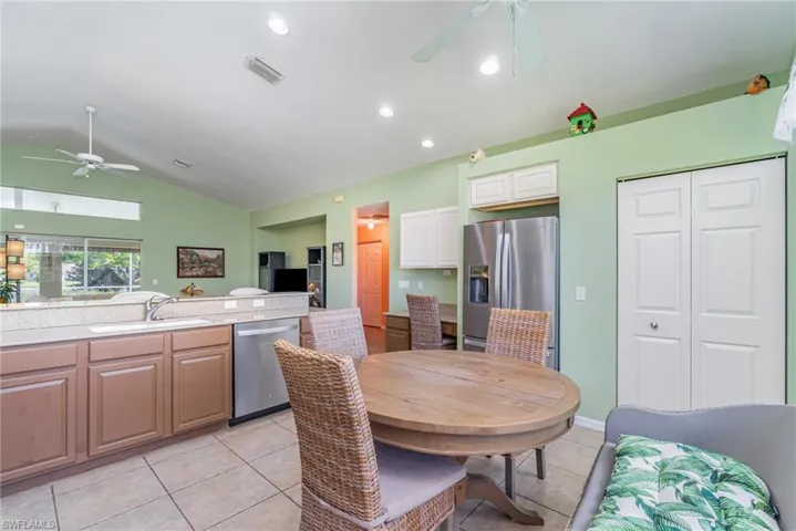 Dining area with ceiling fan, vaulted ceiling, light tile patterned floors, and recessed lighting