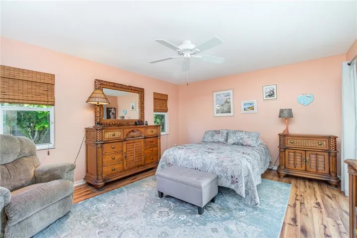 Bedroom with multiple windows, wood finished floors, and a ceiling fan