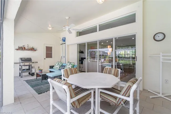 Dining area featuring ceiling fan, light tile patterned flooring, lofted ceiling, and a sunroom