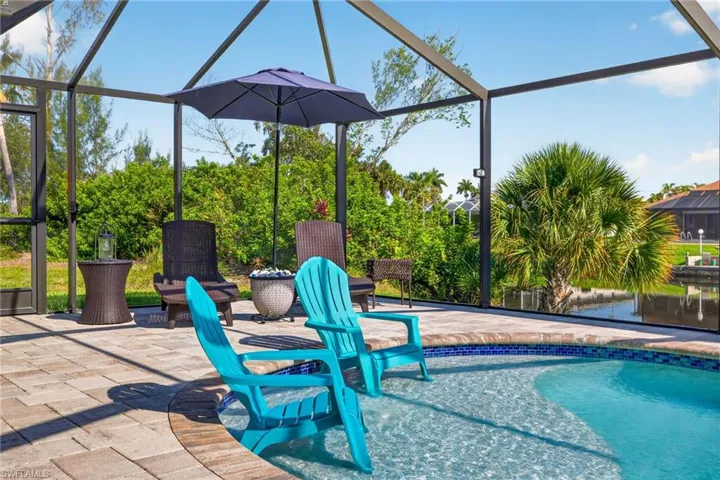 Screened lanai featuring a paver patio and integrated pool with a tiled edge