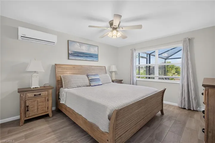 Bedroom featuring tile flooring, a ceiling fan, and a mini-split air conditioning unit