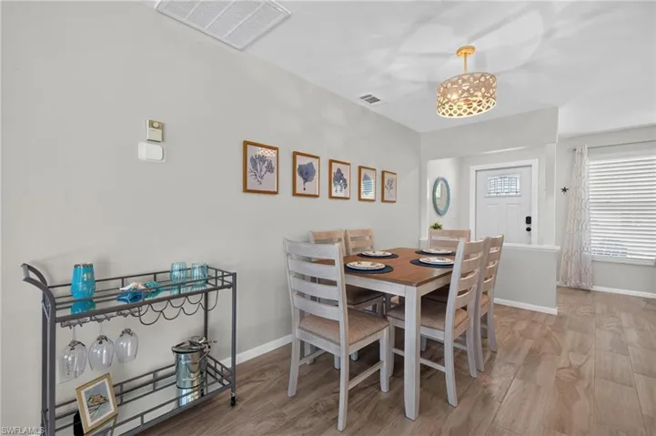 Dining area featuring plank tile flooring, a decorative chandelier, and light gray wall paint