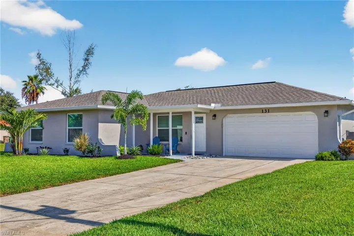 Single-story residence featuring a neutral stucco exterior, a gray shingle roof, and an attached two-car garage