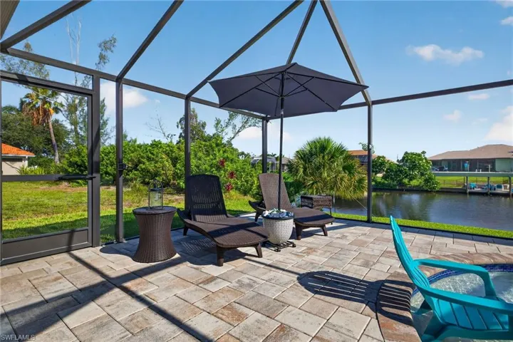Screened outdoor living area featuring a paver patio and direct water access