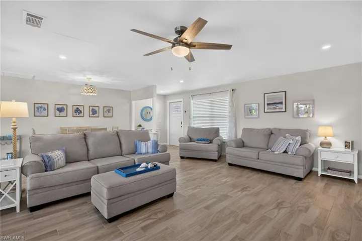 Spacious living area featuring tile flooring, recessed lighting, and a ceiling fan with integrated lighting
