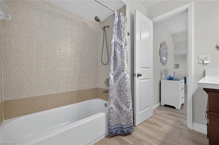 Tub and shower combination featuring a tiled surround with a decorative accent border