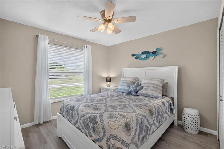 Room featuring tile flooring, a ceiling fan, and a window with blinds and sheer curtains