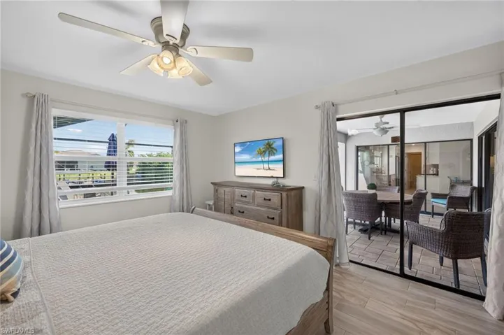 Interior space featuring tile flooring, a ceiling fan with integrated lighting, and a large window with blinds