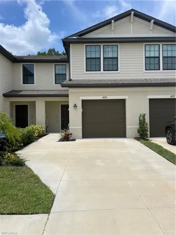 View of front of home with an attached garage, concrete driveway, stucco siding, and roof with shingles