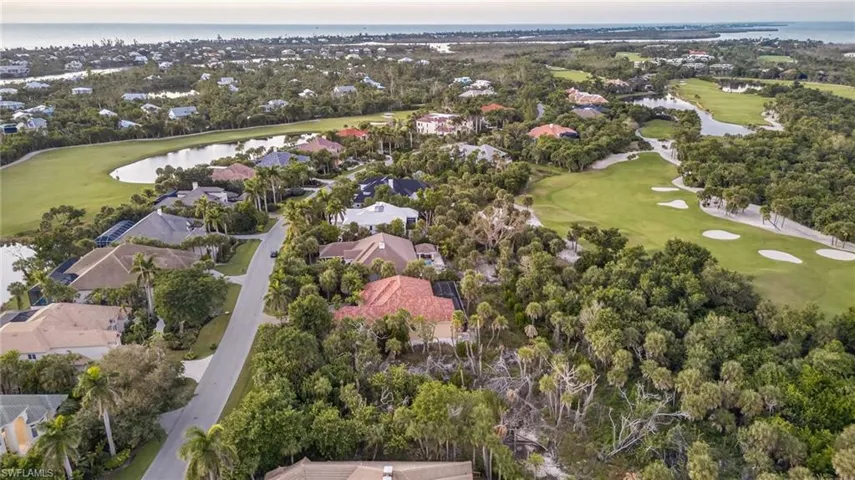 View of property location with a local golf course, a large body of water, and nearby suburban area