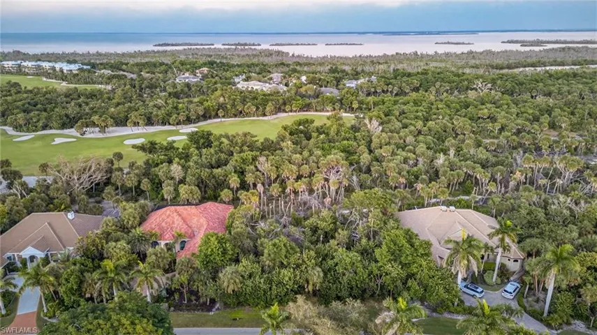 Aerial view of residential area featuring a nearby body of water and a local golf course