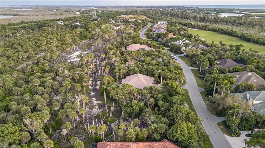Aerial perspective of suburban area with a large body of water and a golf club