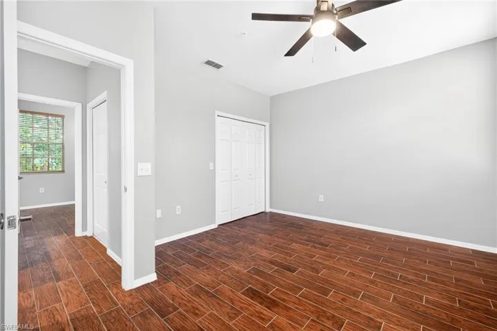 Unfurnished bedroom with a closet, wood tiled floors, and a ceiling fan