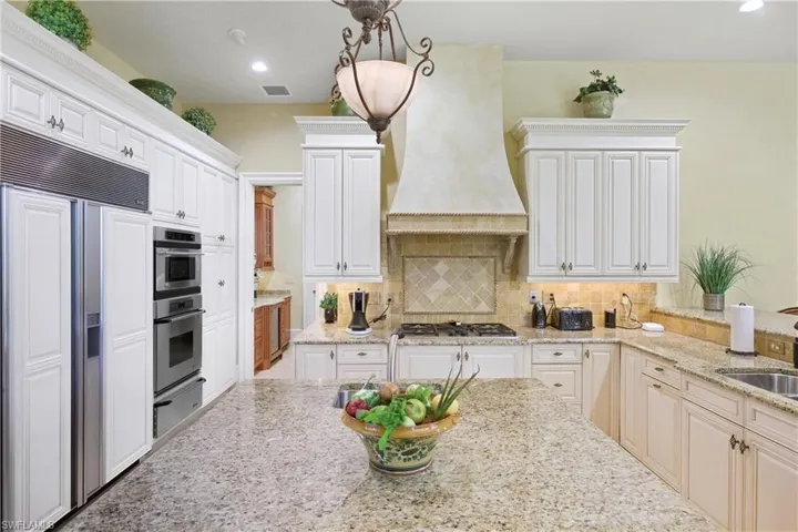 Kitchen with paneled built in fridge, light stone countertops, recessed lighting, backsplash, and a warming drawer