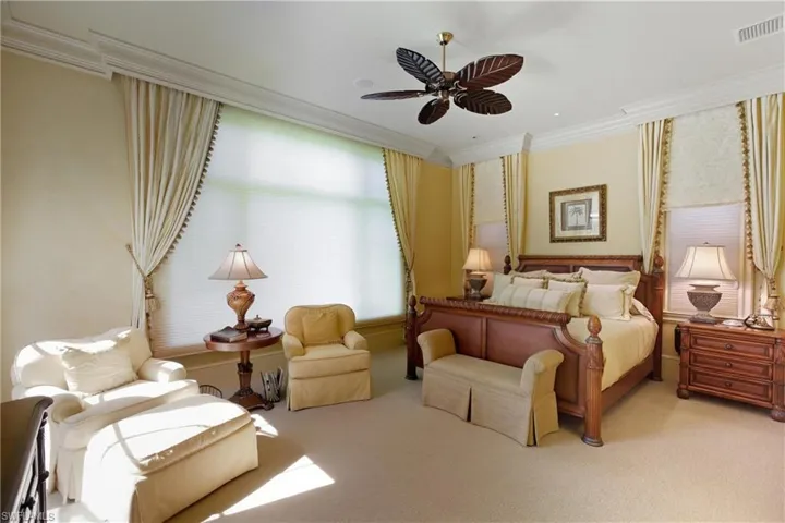 Bedroom featuring ornamental molding, carpet floors, and a ceiling fan