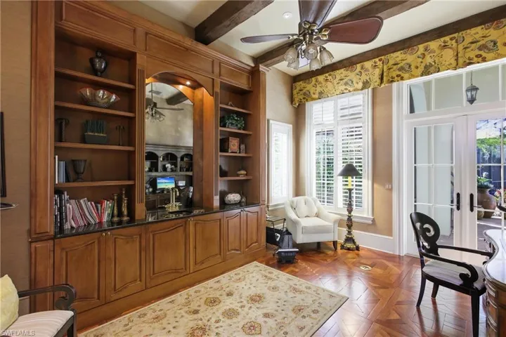 Office space with ceiling fan, french doors, beam ceiling, and built in features