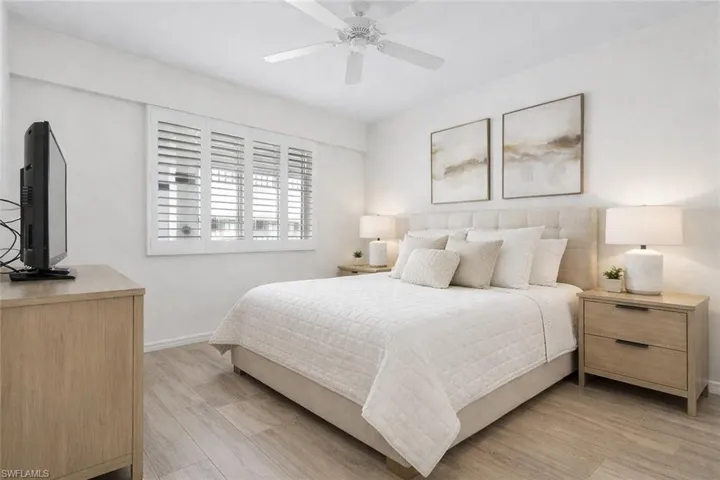 Virtual staged bedroom featuring light wood-style flooring and ceiling fan