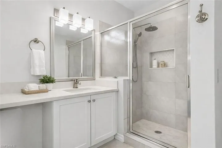 Virtual staged full bath featuring vanity and a shower stall