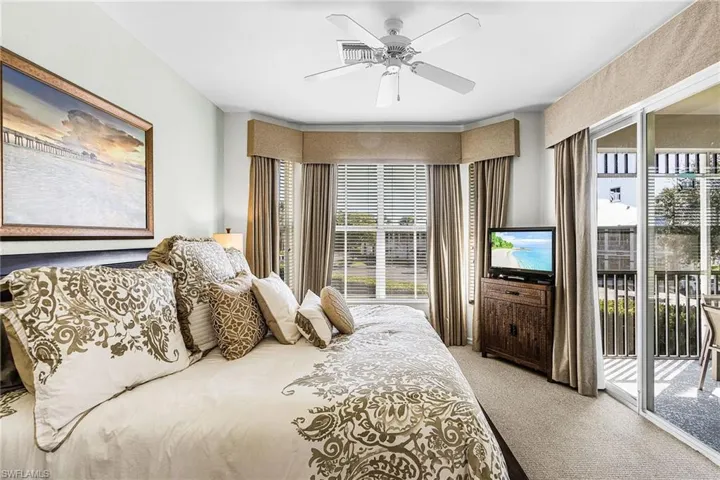 Bedroom featuring light colored carpet, access to exterior, and a ceiling fan