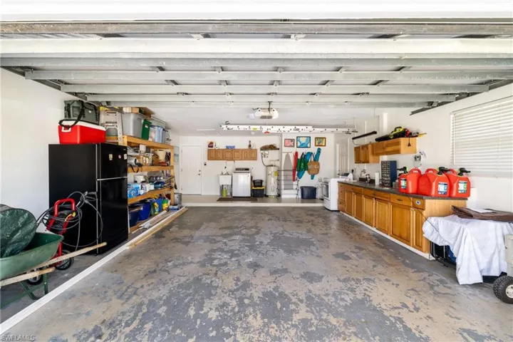 Garage with a garage door opener, water heater, and washer and clothes dryer
