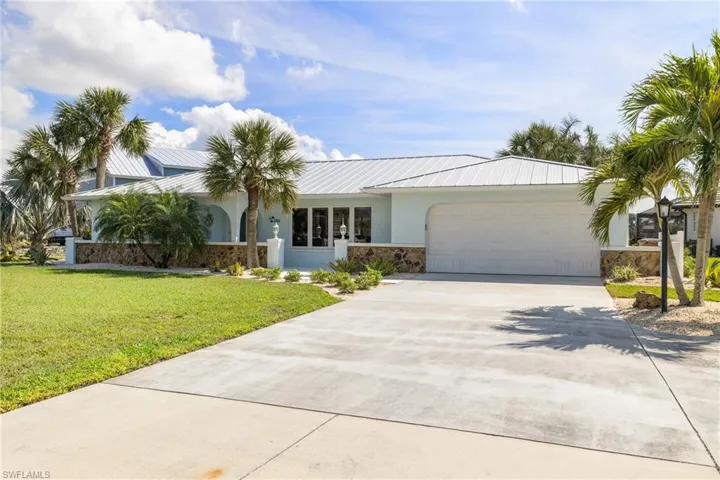 Ranch-style house featuring a front lawn and a garage