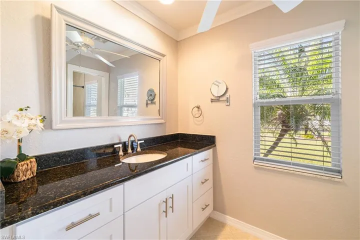 Bathroom featuring tile patterned floors, ceiling fan, vanity, and ornamental molding