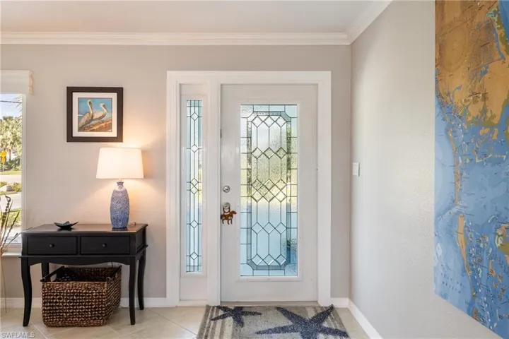 Entrance foyer featuring crown molding and light tile patterned floors