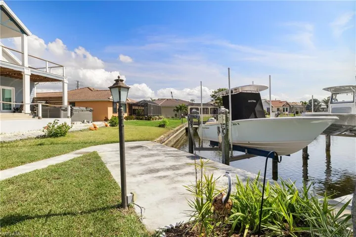 Dock area with a water view and a lawn