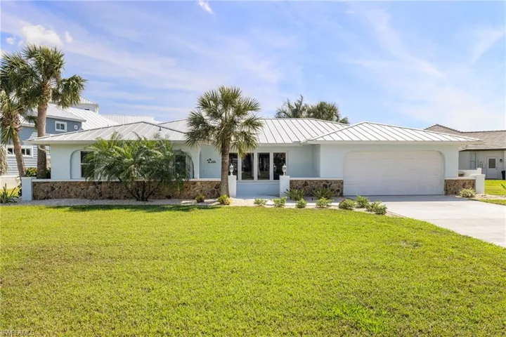 Ranch-style home with a front yard and a garage
