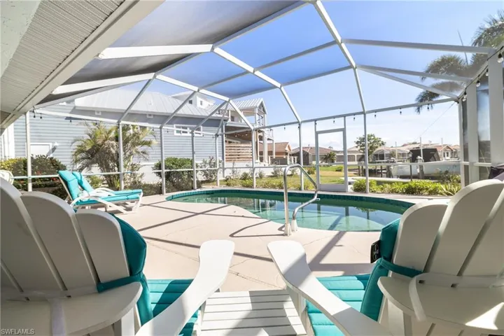 View of swimming pool featuring a patio area and glass enclosure