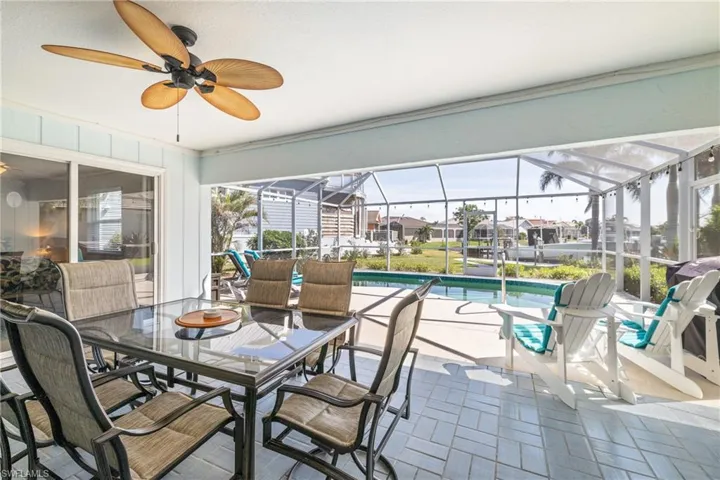 Sunroom featuring ceiling fan and a pool