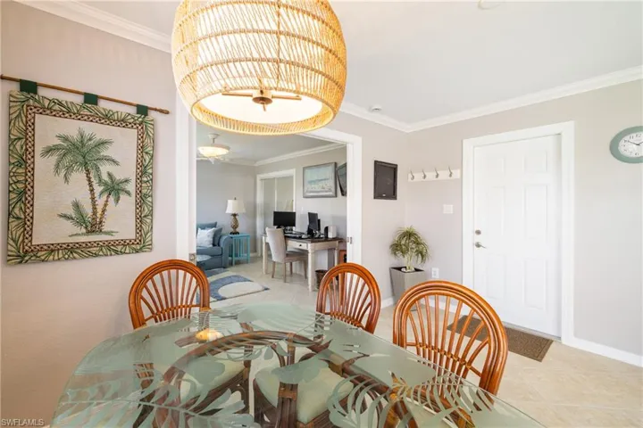 Dining space featuring light tile patterned floors and ornamental molding