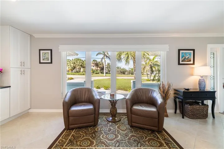 Sitting room with ornamental molding, light tile patterned floors, and a wealth of natural light