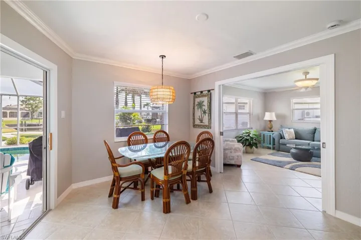 Dining room with ornamental molding, plenty of natural light, and light tile patterned floors