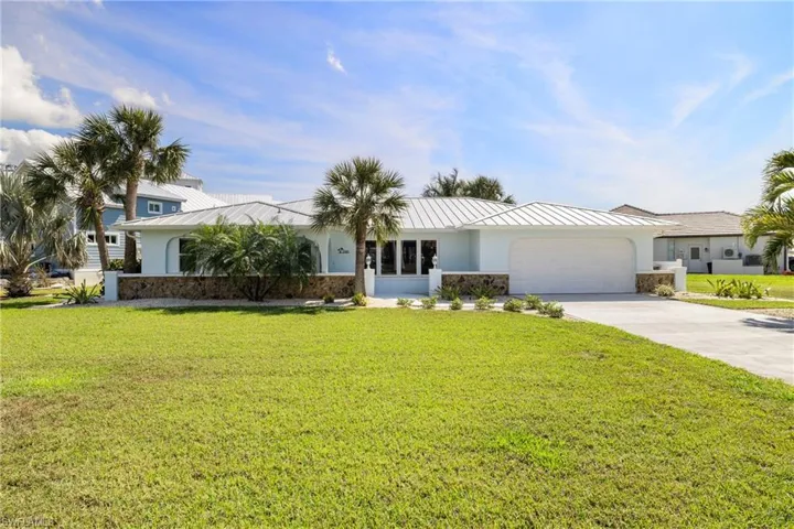 View of front of property featuring a front yard and a garage
