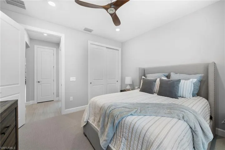 Bedroom featuring light carpet, a closet, and ceiling fan