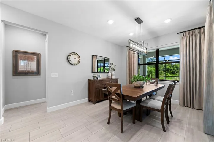 Tiled dining room featuring an inviting chandelier