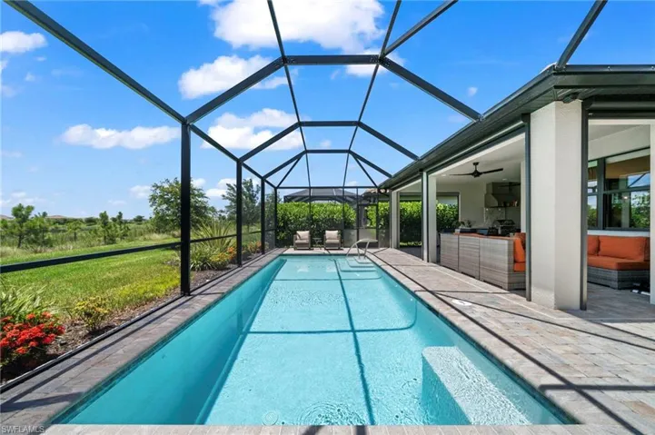 View of pool featuring a lanai, a patio area, and ceiling fan