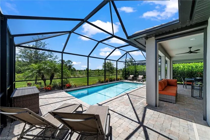 View of swimming pool featuring a patio, a lanai, and ceiling fan