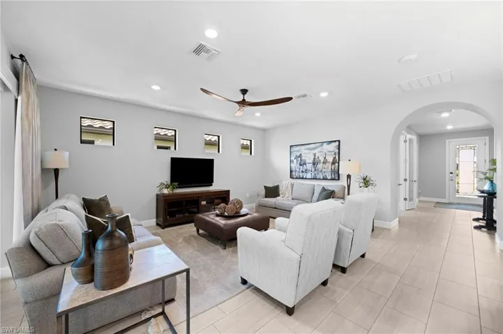 Living room with light tile patterned flooring and ceiling fan