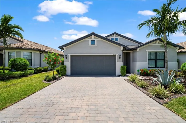 Ranch-style house featuring a garage and a front yard