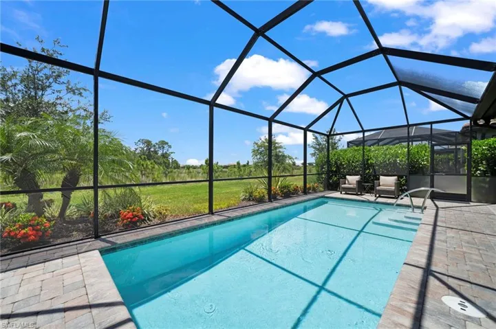 View of pool featuring a patio and glass enclosure