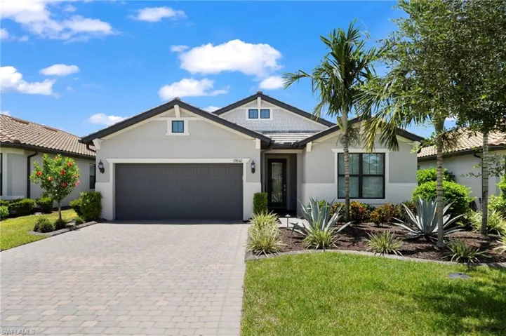 View of front of property with a garage and a front lawn