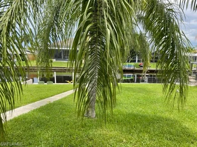 Surrounding community with a yard and a water view
